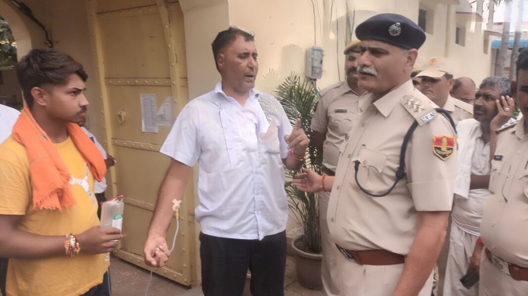 पावटा में ड्रिप लगी हालत में प्रागपुरा थाने के गेट पर लेट गए पूर्व सरपंच, मारपीट का लगाया आरोप